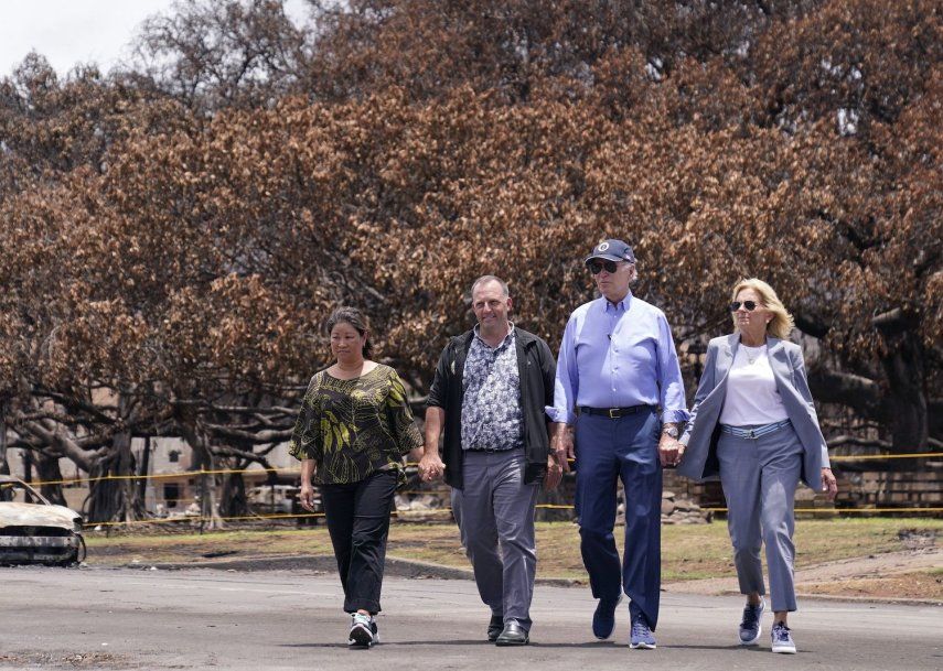 El presidente Joe Biden y la primera dama Jill Biden caminan con el gobernador de Hawai Josh Green, segundo por la izquierda, y su esposa Jaime Green mientras pasan por el enorme árbol Banyan durante su visita a las zonas devastadas por los incendios forestales de Maui, el 21 de agosto de 2023, en Lahaina, Hawai.&nbsp;