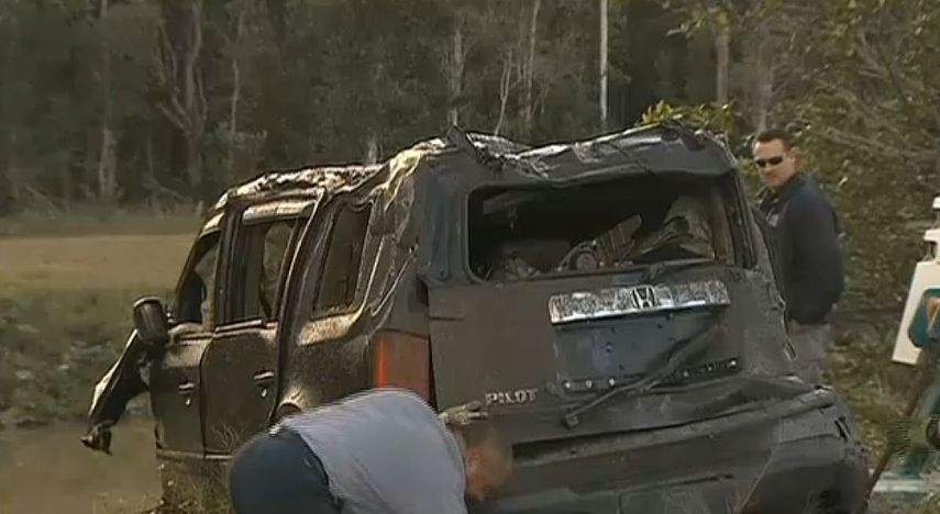 Cuerpos oficiales de Miami examinan el vehículo recién sacado de un canal. (WSVN)