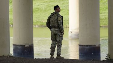 n esta foto de archivo del 26 de agosto de 2022, un miembro de la Guardia Nacional de Texas observa desde el lado estadounidense del río Bravo.&nbsp;