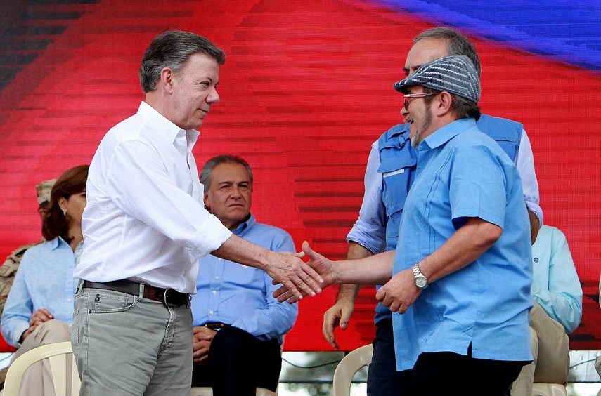 El presidente Juan Manuel Santos (i), estrecha la mano del máximo líder de las FARC, Rodrigo Londoño, alias Timochenko (d), durante la ceremonia de dejación de armas, este martes 27 de Junio de 2017, en Colombia.