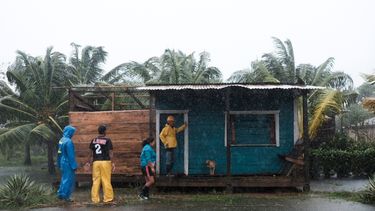 Residentes se paran afuera de una casa rodeada por las inundaciones provocadas por el huracán Eta en Wawa, Nicaragua, el martes 3 de noviembre de 2020.