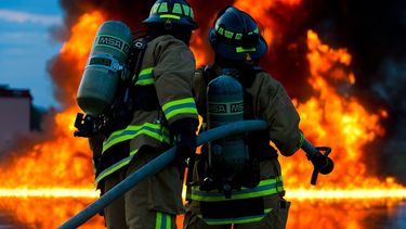 Imagen referencial de dos bomberos ante un gran incendio.&nbsp;