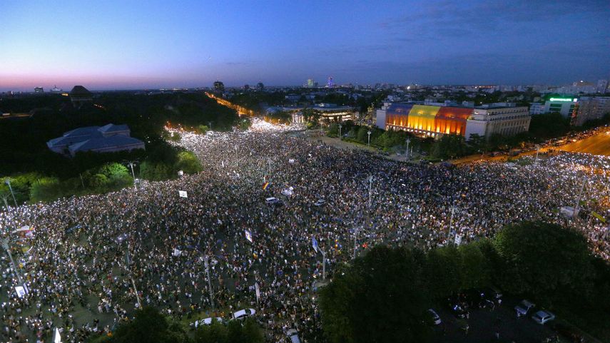 Cientos de manifestantes protestan en una plaza de Bucarest en contra de la corrupción y demandan la renuncia del Gobierno.