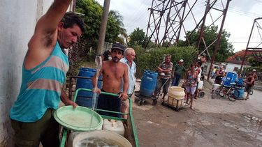 Varias personas con cubos y tanques hacen cola en un punto de agua del oriente cubano.
