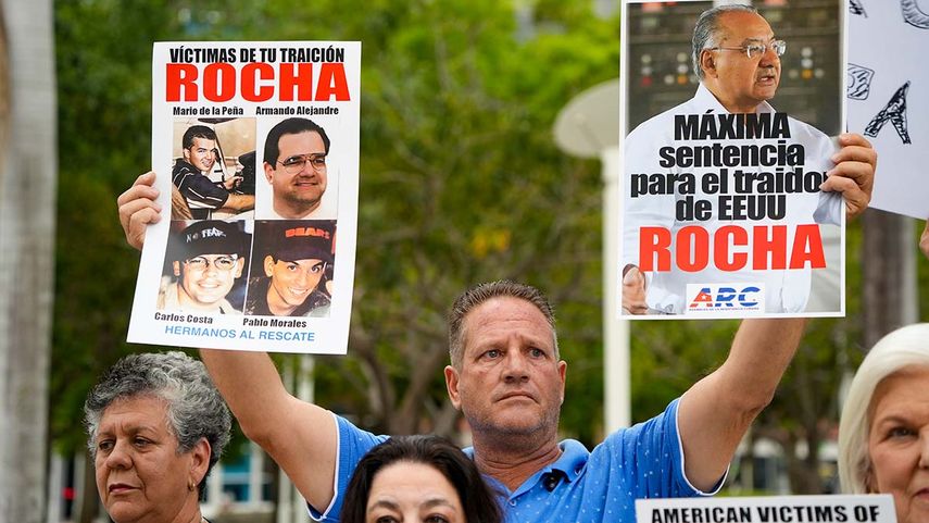 Un manifestante muestra pancartas con la imagen del exdiplomático Víctor M. Rocha