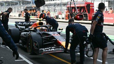 Los mecánicos de Red Bull Racing mueven el coche del piloto japonés Yuki Tsunoda desde el pit lane al garaje durante la primera sesión de prácticas del Gran Premio de Fórmula 1 de la Ciudad de México en el autódromo Hermanos Rodríguez en la Ciudad de México, el 24 de octubre de 2025.&nbsp;
