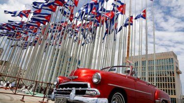 En esta imagen de archivo, un auto descapotable clásico estadounidense pasa junto a la embajada de Estados Unidos en La Habana, Cuba.