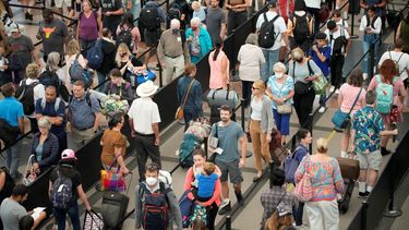 Viajeros se forman para pasar un control de seguridad en el Aeropuerto Internacional de Denver, previo al fin de semana festivo por el Día del Trabajo, el martes 30 de agosto de 2022, en Denver.