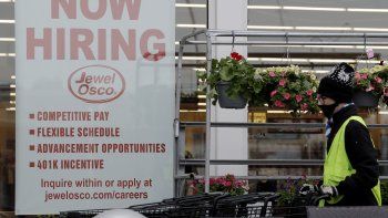 Un empleado empuja carros de compra junto a un aviso de empleos en una tienda de Jewel Osco en Deerfield, Illinois. Un empleado empuja carros de compra junto a un aviso de empleos en una tienda de Jewel Osco en Deerfield, Illinois.