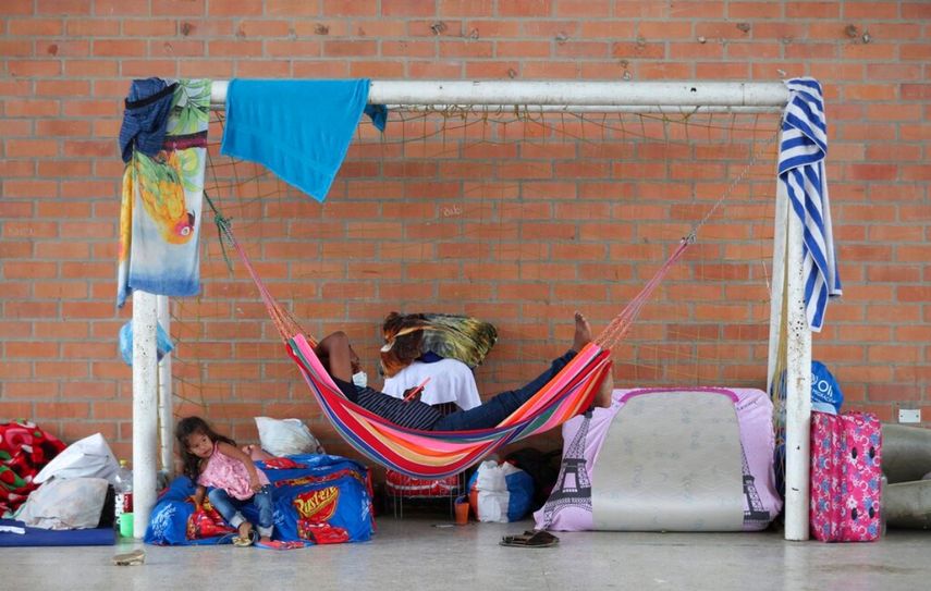 Desplazados venezolanos descansan bajo una portería de fútbol en un refugio instalado en un centro comunitario en Arauquita, Colombia, en la frontera con Venezuela.