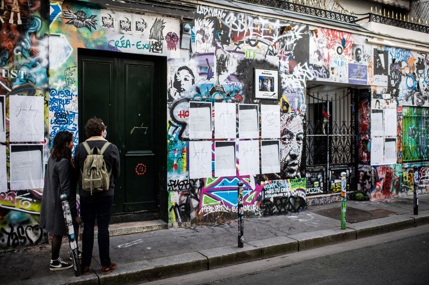 Peatones se encuentran frente a la casa del cantante francés Serge Gainsbourg cubierta de graffitis en la Rue de Verneuil en París, el 2 de marzo de 2021, 30 años después de su muerte.