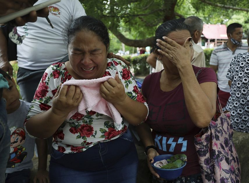 Mujeres lloran mientras explican que tres de sus familiares fueron asesinados el día anterior en El Ripial, estado Apure, Venezuela, luego de cruzar el río hacia Arauquita, Colombia, el viernes 26 de marzo de 2021.