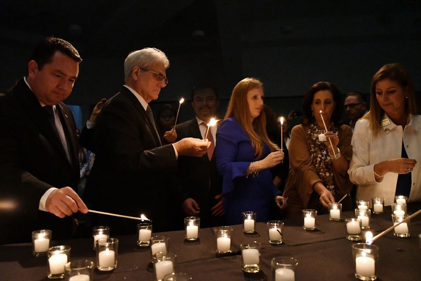 Asistentes al acto conmemorativo encienden velas para recordar a los 85 fallecidos durante el acto terrorista.