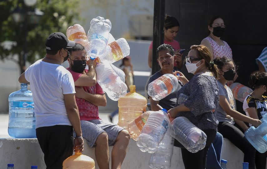 Vecinos esperan para llenar garrafas de plástico con agua en un punto de suministro público en Monterrey, México, el 20 de junio de 2022. Las autoridades locales comenzaron a restringir el suministro de agua en marzo debido a la combinación de una intensa sequía, una mala planificación y un uso excesivo que ha secado las tres presas que abastecen a la ciudad, y miles de viviendas no reciben agua desde hace semanas.&nbsp;