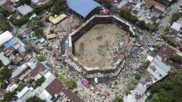 En esta imagen tomada de un video, espectadores se aglomeran cerca de donde se derrumbaron varios palcos armados en forma improvisada y con gente en ellos durante una corrida de toros en la ciudad de El Espinal, departamento de Tolima, en Colombia, el domingo 26 de junio de 2022.&nbsp;