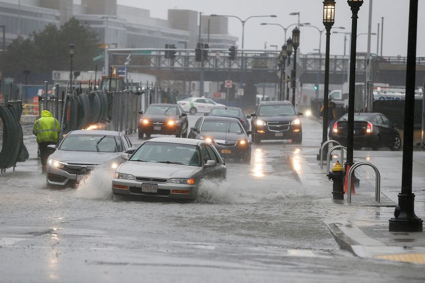 Varios coches circulan entre las calles inundadas durante el&nbsp;temporal&nbsp;cerca del distrito de Seaport, en Boston, Massachusetts.