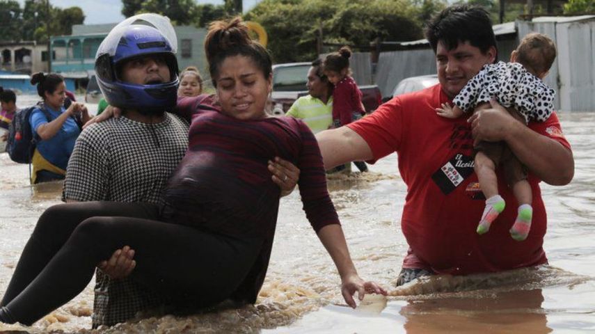 Una mujer embarazada es sacada de un área inundada por el agua traída por el huracán Eta en Planeta, Honduras.
