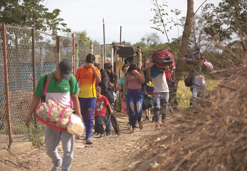 Fotografía del 31 de agosto de 2018 de un grupo de venezolanos que cruzan ilegalmente a Colombia por un camino conocido como trocha, lejos del control de las autoridades.