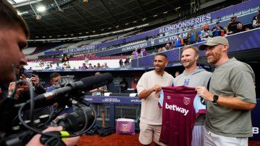 Pete Alonso, de los Mets de Nueva York, posa para una foto con los exfutbolistas del West Ham, Anton Ferdinand y James Collins, durante un día de entrenamiento en el estadio de Londres, el viernes 7 de junio de 2024.