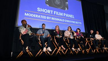 El poeta estadounidense y defensor de la reforma penitenciaria Reginald Dwayne Betts (izq.) dirige un panel con cineastas durante el Festival de Cine de San Quentin en el Centro de Rehabilitación de San Quentin en San Quentin, California, el 24 de octubre de 2025.