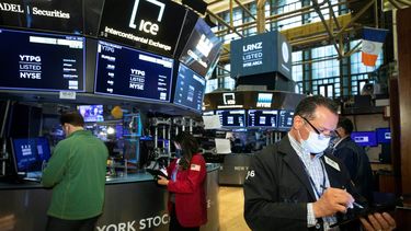 Agentes en Wall Street trabajan en el piso de remate.