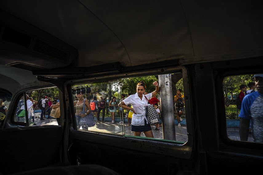 La gente espera en una parada de transporte público mientras mira un taxi colectivo en La Habana, Cuba, el martes 4 de abril de 2023.&nbsp;