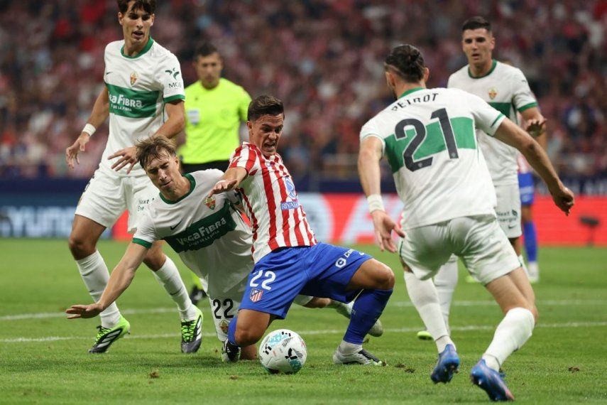 El defensa austriaco #22 del Elche, David Affengruber, cae junto al delantero italiano #22 del Atlético de Madrid, Giacomo Raspadori, durante el partido de la liga española entre el Club Atlético de Madrid y el Elche CF en el Estadio Metropolitano de Madrid el 23 de agosto de 2025.&nbsp;