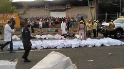 Parte de los migrantes fallecidos en accidente tendidos en la acera en Tuxtla Gutiérrez, estado de Chiapas, México, el 9 de diciembre de 2021.