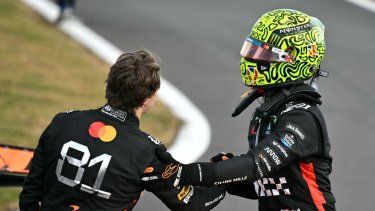 El piloto británico de McLaren, Lando Norris (D), estrecha la mano de su compañero de escudería, el australiano Oscar Piastri, después de ganar el Gran Premio de Gran Bretaña de Fórmula 1 en el circuito de automovilismo de Silverstone, en el centro de Inglaterra, el 6 de julio de 2025.
