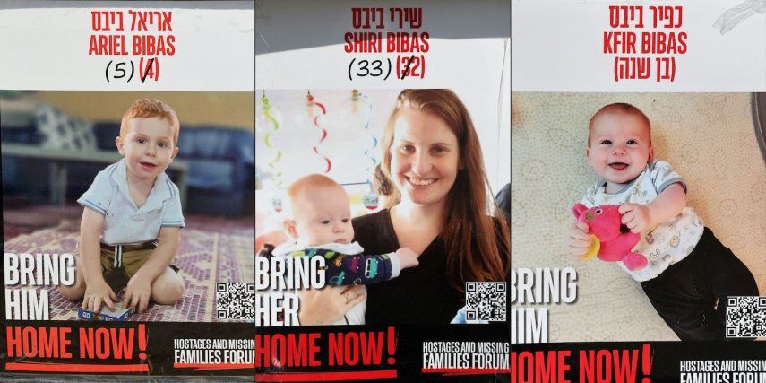 Carteles con los retratos de los rehenes israelíes Shiri Bibas (centro) y sus dos hijos Ariel (izq.) y Kfir (der.), retenidos en la Franja de Gaza desde el ataque del 7 de octubre de 2023 por militantes de Hamás, colocados en una plaza frente al Museo de Arte de Tel Aviv, el 21 de enero de 2025.