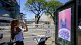 Una fanática de Taylor Swift toma una fotografía de un cartel que muestra un retrato inspirado en la cantante que tiene unas galletas con la frase Massa 2023, en el Estadio Monumental, antes de que se abran las puertas para el concierto de Swift en Buenos Aires, el jueves 9 de noviembre de 2023.