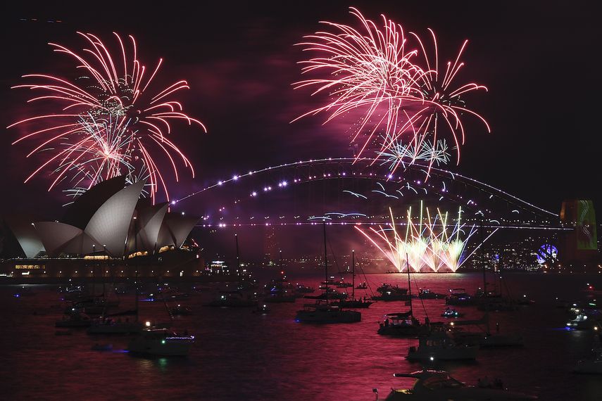Fuegos artificiales iluminan el puente y la ópera de Sydney en el inicio de los festejos de Año Nuevo, el Sydney, el 31 de diciembre de 2021.