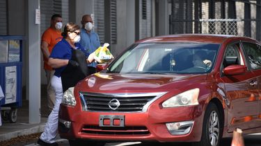 Empelados del Distrito escolar entregan alimentos a padres de estudiantes.