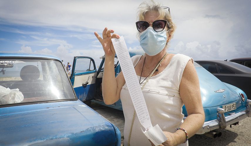 Una mujer muestar el recibo de una compra que pagó en dólares en La Habana.