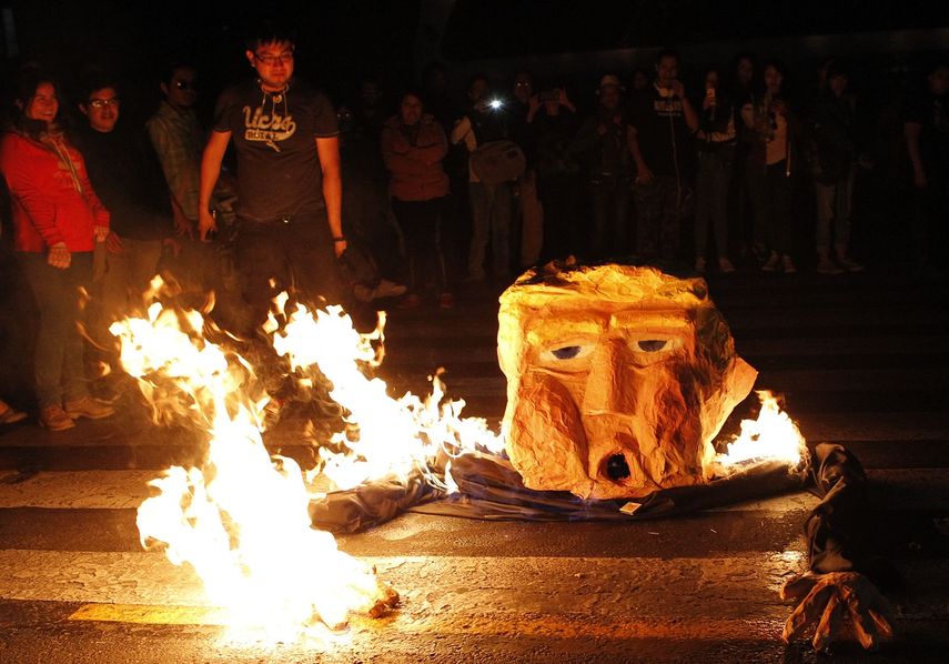 Un grupo de personas quema un muñeco este viernes 20 de enero de 2017 en Ciudad de México, durante una protesta contra la investidura de Donald&nbsp;Trump&nbsp;como presidente de Estados Unidos.