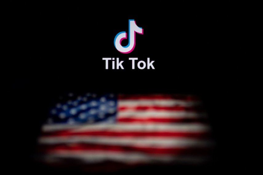 La foto muestra el logotipo de la aplicación de red social TikTok (arriba) y una bandera de Estados Unidos (abajo) en las pantallas de dos computadoras.