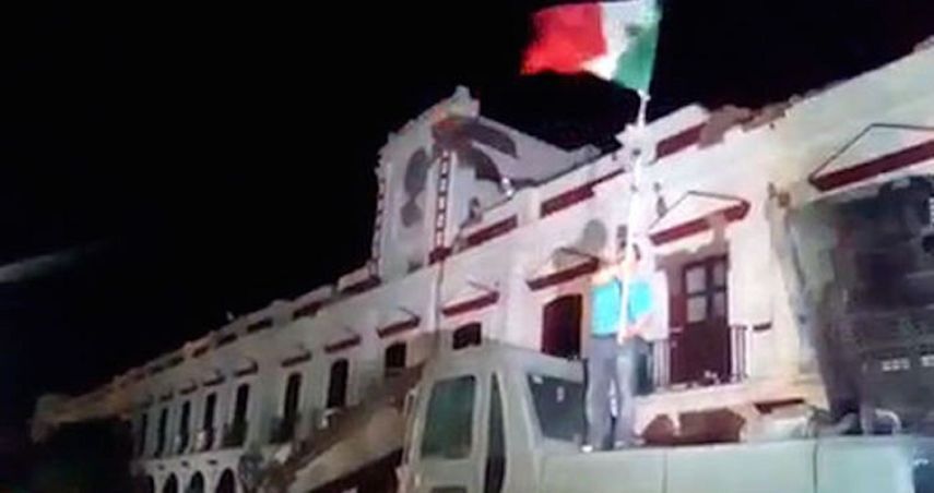 En un intento por levantar el ánimo, en la noche un ciudadano tomó una bandera que ondeó trepado sobre una excavadora.