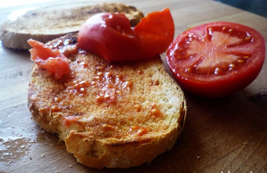 La muestra de Cosmocaixa se refiere a los productos culinarios necesarios para el pan con tomate: el tomate, el olivo, el aceite, el trigo, la harina, la sal, el agua, pero también el cuchillo, la aceitera, la madera para cortar y el plato