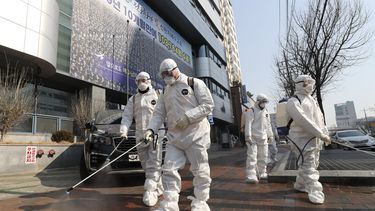 Trabajadores roc&iacute;an desinfectante frente a una iglesia en la ciudad de Daegu, Corea del Sur, el jueves 20 de febrero de 2020.&nbsp;