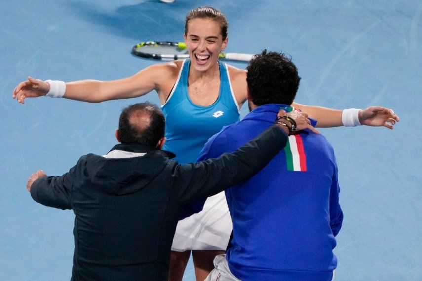 La tenista italiana Lucia Bronzetti (centro) celebra con el capitán del equipo, Vincenzo Santopadre, y con su compañero de equipo, Matteo Berrettini, tras superar a la griega Valentini Grammatikopoulou en el último partido de la semifinal de la United Cup, en Sídney, Australia, el 7 de enero de 2023.