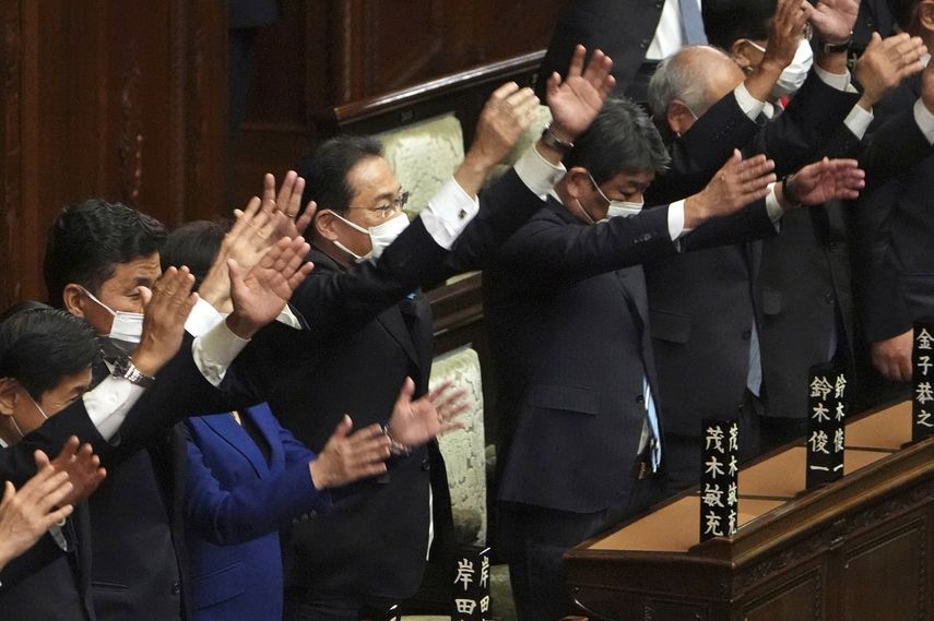 El primer ministro de Japón, Fumio Kishida (centro), y otros legisladores dan tres vivas tras disolver la cámara baja, la más poderosa de las dos del parlamento, durante una sesión extraordinaria, en Tokio, el 14 de octubre de 2021.&nbsp;