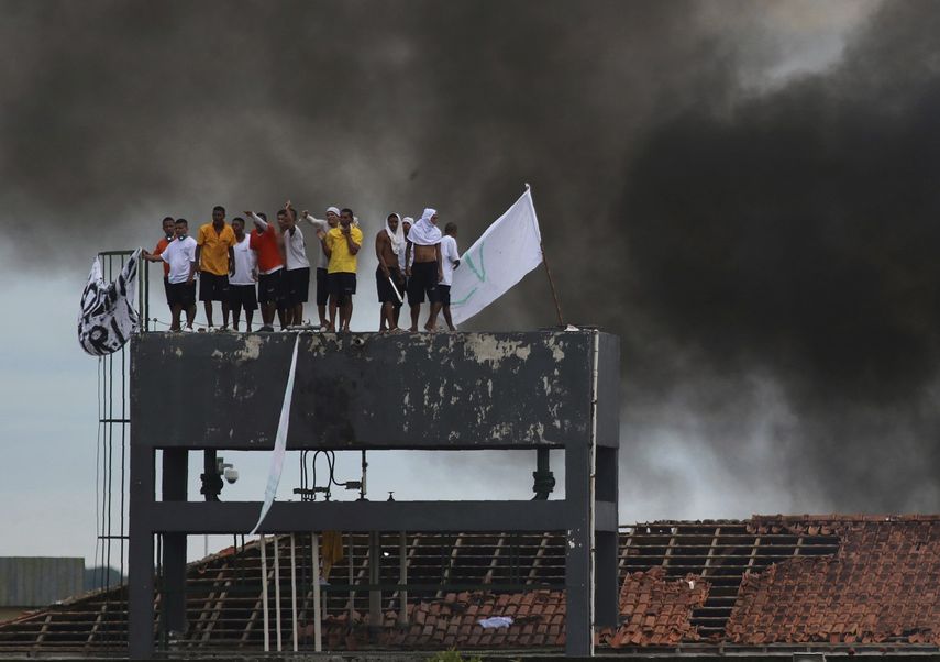 En esta imagen, tomada el 2 de mayo de 2020, reos de la prisi&oacute;n Puraquequara, de pie sobre una torre de agua, protestan por las malas condiciones del penal y por las restricciones en las visitas de familiares adoptadas para frenar el coronavirus, en Manaos, Brasil.&nbsp;