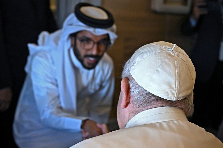 El Papa Francisco (D) le da la mano a un periodista desde su asiento a bordo del avión de Roma a Manama durante su visita a Baréin el 3 de noviembre de 2022.