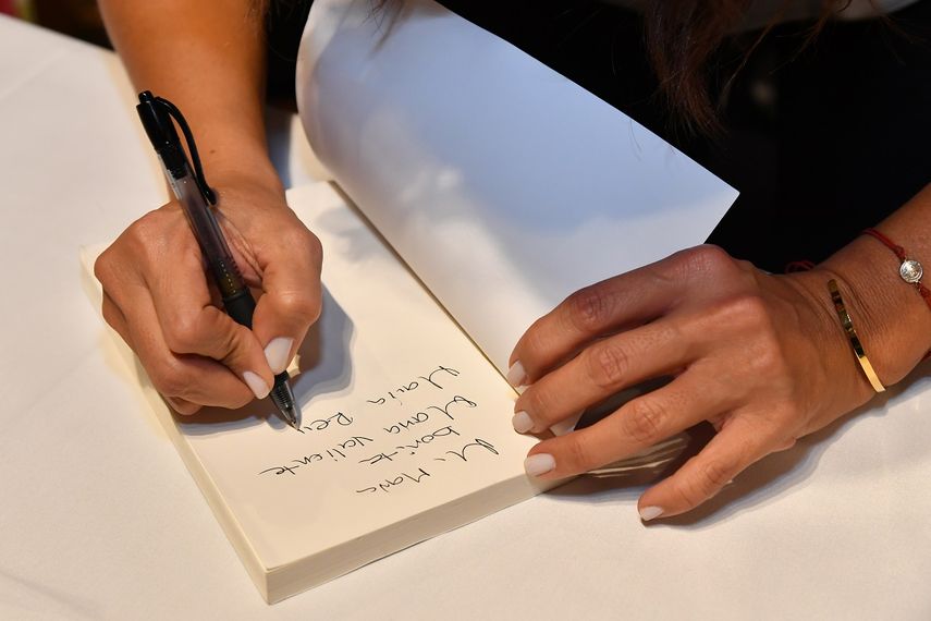 Paula Arcila firma uno de los ejemplares de Una reina sin medidas.&nbsp;