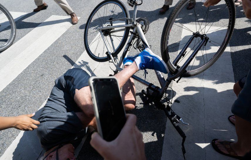 El presidente de los Estados Unidos, Joe Biden, se cae de su bicicleta cuando se acerca a los simpatizantes después de un paseo en bicicleta en el Parque Estatal Gordons Pond en Rehoboth Beach, Delaware, el 18 de junio de 2022.