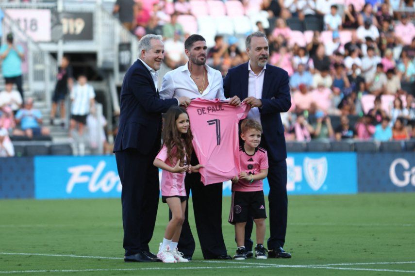 Rodrigo De Paul (centro) posa junto a José y Jorge Mas, copropietarios del Inter Miami CF, en su presentación como nuevo jugador del club, el 26 de julio de 2025 en Fort Lauderdale, Florida.