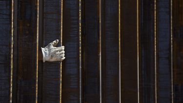 La mano enguantada de un alba&ntilde;il se ve a trav&eacute;s de una parte de la cerca de 9 metros (30 pies) de altura mientras contin&uacute;a la construcci&oacute;n del muro fronterizo entre M&eacute;xico y Estados Unidos a unos 3 kil&oacute;metros (2 millas) al oriente del puerto de entrada en Lukeville, Arizona, el 8 de octubre de 2019.&nbsp;