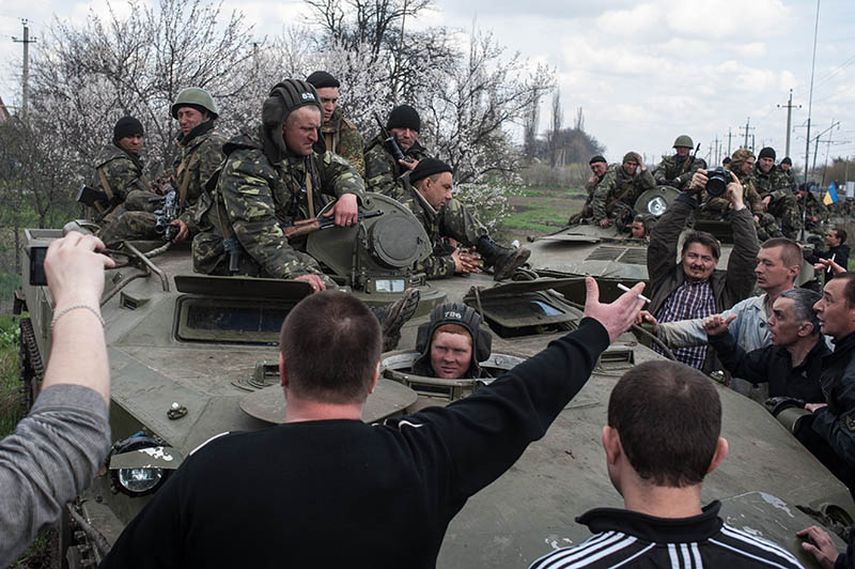 Unas personas bloquean el paso de vehículos del ejército ucraniano que se dirigen al poblado de Kramatorsk, Ucrania, el miércoles 16 de abril de 2014.