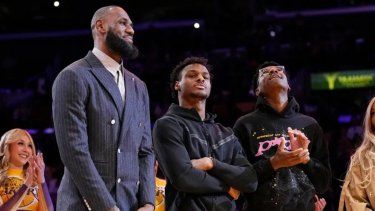 El alero de los Lakers, LeBron James (segundo desde la izquierda), Bronny James (centro) y Bryce James se paran durante una ceremonia en honor al astro como el máximo anotador de todos los tiempos de la NBA, antes del partido de baloncesto de Los Ángeles contra los Bucks de Milwaukee, el 9 de febrero de 2023 en Los Ángeles.