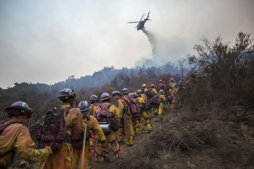 Un helicóptero arroja agua durante el incendio llamado Holy, en Lake Elsinore, California.